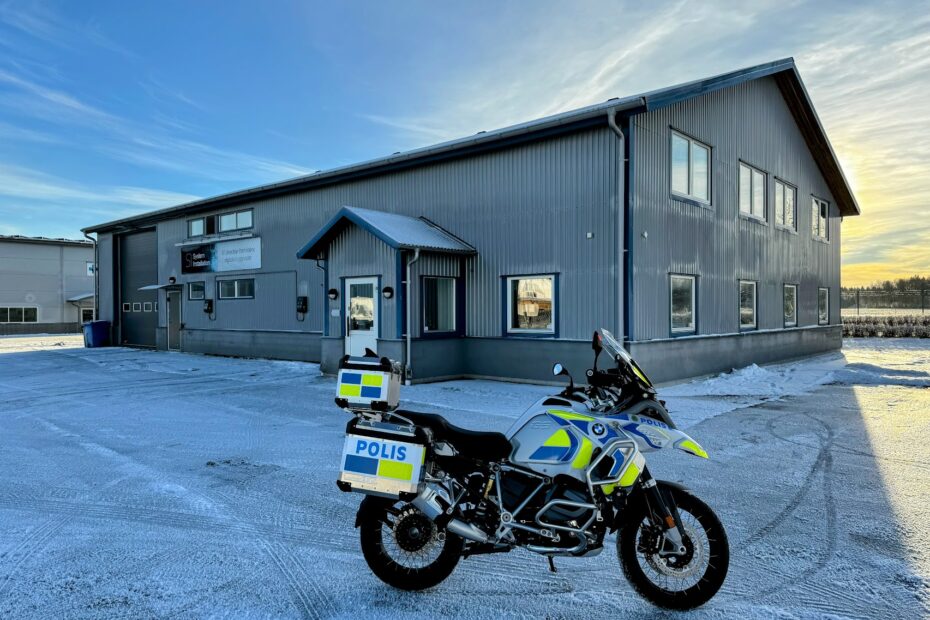 polismotorcykel framför grå byggnad
